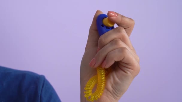 Жінка натискає кнопку на клікер, коли собака робить речі — стокове відео