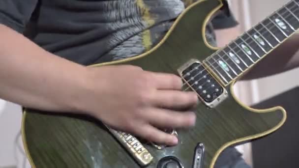Мужчина играет рок-музыку на зеленой бас-гитаре на групповой практике — стоковое видео