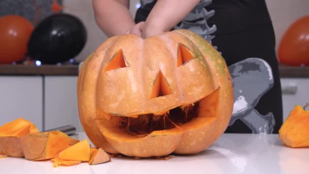 La persona fa jack-o-lanterna di zucca per decorare la casa per la festa di Halloween, da vicino. Lui o lei tira fuori le interiora di zucca con la mano per fare spazio alla candela — Video Stock