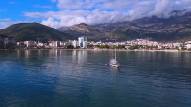 Gök mavisi denizdeki sönmüş yelkenli büyük turizm şehrinin yakınlarında.