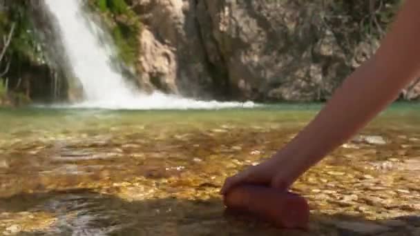 Młoda kobieta wlewa świeżą wodę z jeziora do plastikowej butelki. — Wideo stockowe