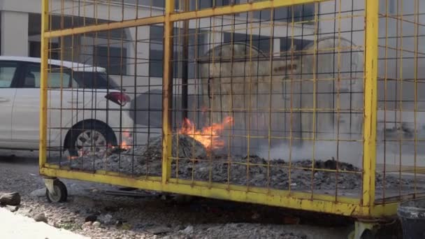 Plastic waste burns in metal bin leaving white harmful smoke — Stock Video