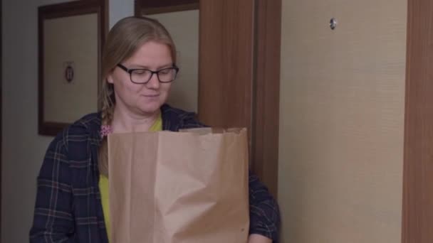 Vrouw met bril wordt bang en gooit tas in kamer — Stockvideo
