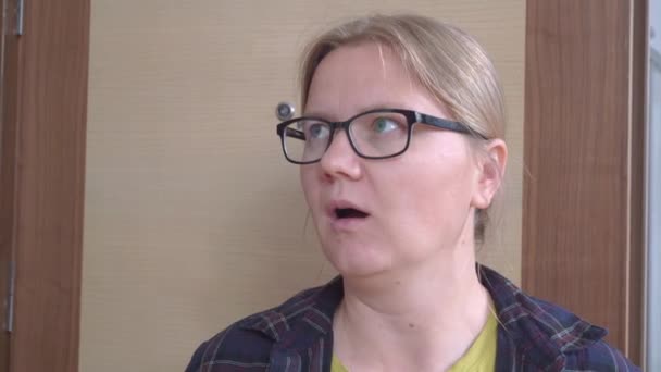 Junge blonde Frau mit Brille, die vor Überraschung den Mund weit aufmacht, sie traut ihren Augen nicht und schaut sich verwirrt um, als sie versucht, eine Lösung für das Problem zu finden — Stockvideo