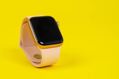 29 Mayıs, Rostov, Rusya: Apple Watch serisi 6, sarı arka planda pembe lastik kayış, kopyalama alanı. Etkin bir yaşam biçimi için akıllı aygıt.