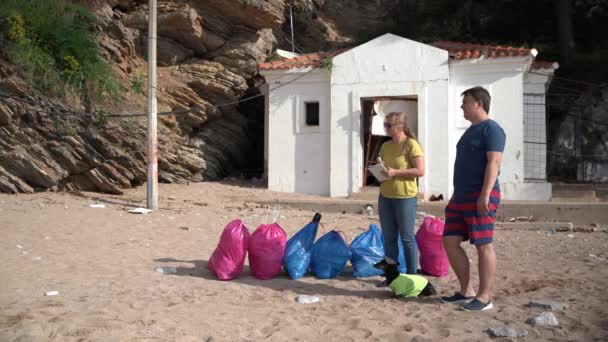 Den trente dachsundvalpen hjelper frivillige med å rydde søppel på stranden. Unge menn og kvinner samlet inn søppel i poser som skulle kastes eller sendes til gjenvinning. Samfunnstjeneste – stockvideo