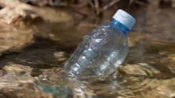 Botella de plástico usado flota en el agua, de cerca. Lucha contra la contaminación ambiental, ayuda a la naturaleza. Sobreabundancia de residuos plásticos. Problema crítico de gestión global de residuos — Vídeos de Stock
