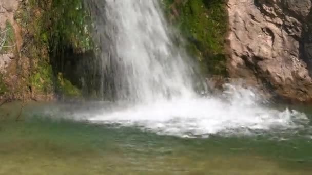 Jets of waterfall and transparent lake near old stone cliff — Stock video