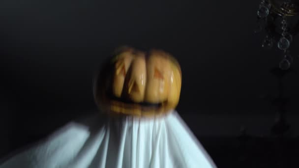 Osoba dělá horor divný výkon na Halloweenské párty pro přátele. Herec v domácím duchařském kostýmu s dýní s děsivým obličejem místo hlavy a hračky v ruce se objeví v rámečku