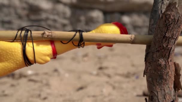 Toy rubber chicken spins around tied to makeshift wooden spit, close up. Grotesque performance of vegetarianism. Do not harm the animals. Meals on a hike or picnic — Stock Video