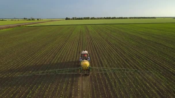 Landbouwtrekker met gele sproeier spruitjes — Stockvideo