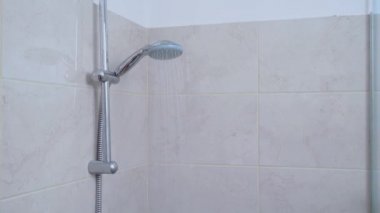 Sıcak su modern banyodaki duştan aşağı akıyor.