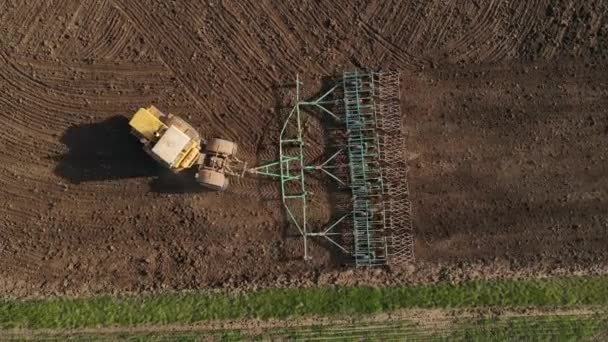 Gelber Traktor mit Pflug fährt Feldweg entlang — Stockvideo