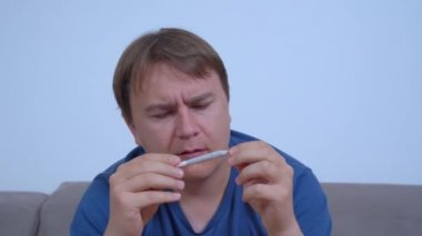 Genç, beyaz bir adam sigarasını sarar ve sigara kokusunu içine çeker. Kronik ağrı kontrol için tıbbi marihuana, kas gevşetici olarak, glokom ve diğer sağlık sorunlarını tedavi etmek için