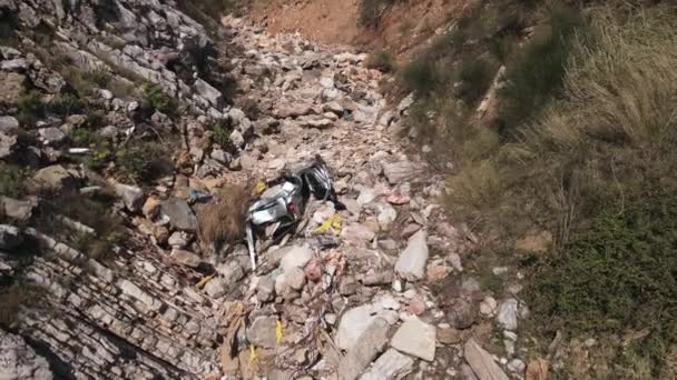 Abandonado cinza automóvel destruído encontra-se na colina rochosa — Vídeo de Stock