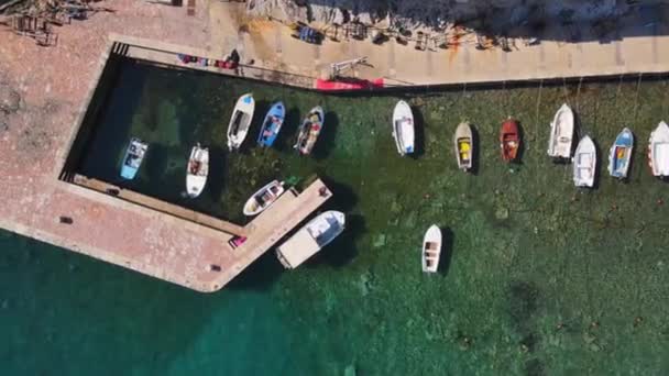Boten afgemeerd op de vissteiger in Petrovac op zonnige dag, Montenegro, vogels-oog uitzicht van boven, drone schieten. Een kleine Europese vissersstad — Stockvideo