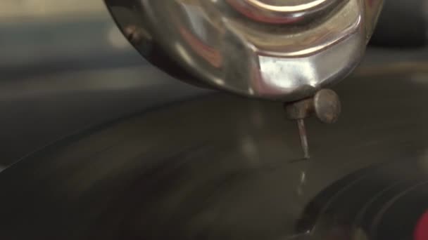 Caixa de som de metal com agulha enferrujada seguindo uma ranhura em disco rotativo de vinil para reproduzir sons e música, usando um gramofone antigo, de perto — Vídeo de Stock