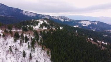 İnsansız hava aracı Saraybosna, Bosna-Hersek 'teki terk edilmiş Olimpiyat parkının üzerinden uçuyor. Karla kaplı yamaçta nadir bulunan kozalaklı orman, panoramik manzara