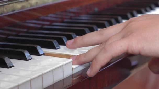 Acemi ilk kez piyano çalıyor, beceriksizce tuşlara basıyor, kapatıyor, yandan seyrediyor. Müzik enstrümanları çalmayı öğrenmek. Hobi ve eğlence konsepti — Stok video