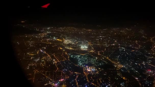 İstanbul 'un gece kalkış ya da iniş sırasındaki pencere camından güzel büyüleyici bir manzara. Seyahat blogu için içerik. Uçak şehrin üzerinde daireler çiziyor. — Stok video
