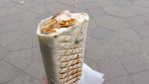 Tangan orang memegang panjang panggang shawarma juicy dengan serbet — Stok Video