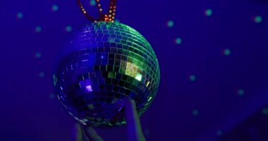 Salonda tavanda asılı duran disko topuna dönüşen insan eli