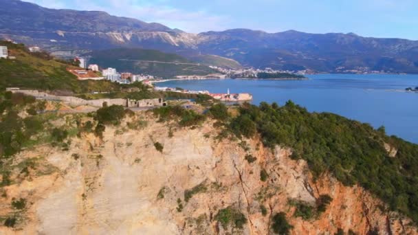 Schießen mit Drohnen, die einen Berg umfliegen, der ins Meer ragt. Ruinen einer mittelalterlichen Festung auf einer steilen Klippe aus der Vogelperspektive. Historische Sehenswürdigkeit in der Altstadt — Stockvideo