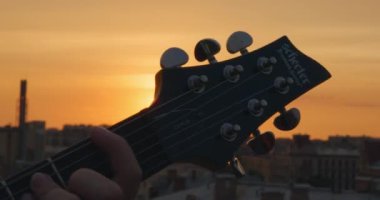 Sanatçı gün batımında festival konserinde solo gitar çalıyor.