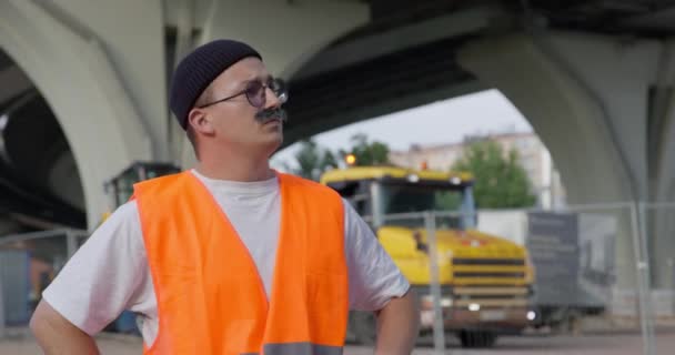 Уборщик настраивает усы и отжимает руки на городской улице — стоковое видео
