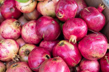 Markette canlı, olgun narlar sergileniyor, zengin kırmızı renkleri ve doğal dokuları sergileniyor, sağlıklı yemek ve hasat temaları için mükemmel..