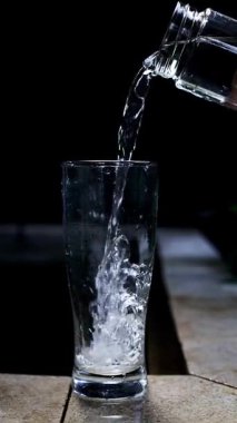 Dramatik Taze İçme Suyunun Yakın Çekimi Cama Dökülüyor, Kabarcıklar Yükseliyor, Siyah Arkaplanda İzole Edilmiş