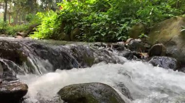 Kayaların arasından akan akarsu. Akan suyla nehir taşlarına yaklaş.
