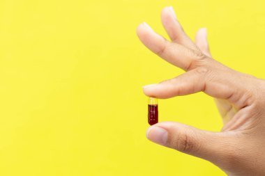 El Tutma Kırmızı Softgel Kapsülü Temel Omega 3 Vitamin veya Parlak Sarı Arkaplan Besleyici