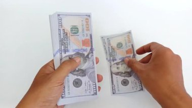 Beyaz arka planda Amerikan dolarlarını sayan bir elin yakın çekimi. Finans, bankacılık, iş ve işlem temaları için elverişli. 