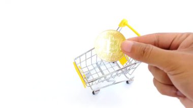 El, modern ekonomide kripto ticaretini, dijital alışverişi ve dijital finansmanı sembolize eden küçük bir alışveriş arabasına sahte Bitcoin yerleştirir..