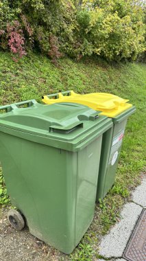 Evin önündeki yeşil çöp tenekesi. Yol kenarında umumi çöp kutusu..