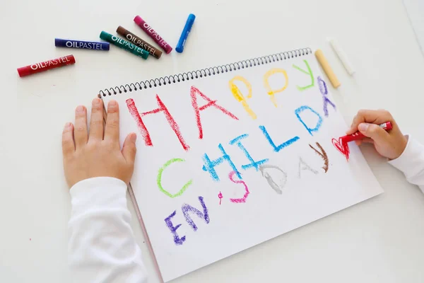 Kid creating bright crayon artwork on paper, rainbow colors, childrens creativity and early learning, art class concept