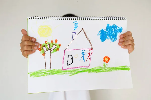 Colorful child drawing with house, tree and flower using crayons. Simple artistic composition symbolizing imagination, childhood joy and creative learning activities.