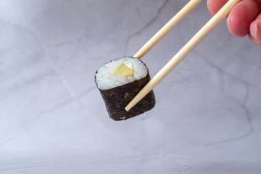 Yakın plan - yemek çubuklarıyla lezzetli suşi rulosu manzarası 