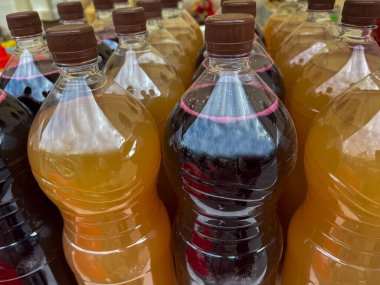 İki tip ev yapımı içecekle dolu plastik şişeler.