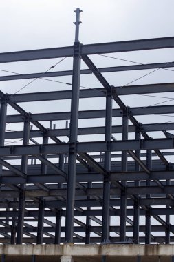 Şehir inşaatı için modern mimari, yapı mühendisliği ve endüstriyel tasarım elementlerinin sergilendiği kirişleri, çapraz destekleri ve merdiven platformları olan endüstriyel çelik iskelet.