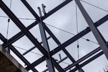 Şehir inşaatı için modern mimari, yapı mühendisliği ve endüstriyel tasarım elementlerinin sergilendiği kirişleri, çapraz destekleri ve merdiven platformları olan endüstriyel çelik iskelet.