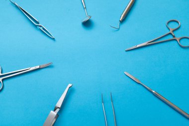 Açık mavi arkaplanda cerrahi aletler