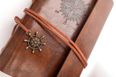  Bej kağıdın üzerinde duran gerçek deriden yapılmış el yapımı bir günlük. Ahşap arka planda eski bir deri kitap. Kahverengi deri kapaklı el yapımı kağıt günlük defteri.