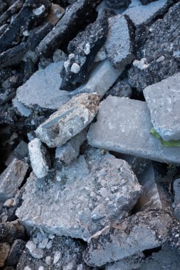 Kırık beton ve asfalt moloz yığını, inşaat alanının yıkıntıları, ezilmiş taş ve betonun kaba dokusu, yol üstüne atık madde veya bina tahribatı.