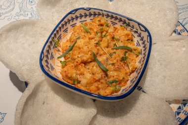 Asya 'dan esinlenilmiş aperatif kremalı karides tartı otlar ve balık yumurtası karışımı, seramik bir kasede çıtır pirinç krakerleriyle servis ediliyor, gurme yemeği için mükemmel.,