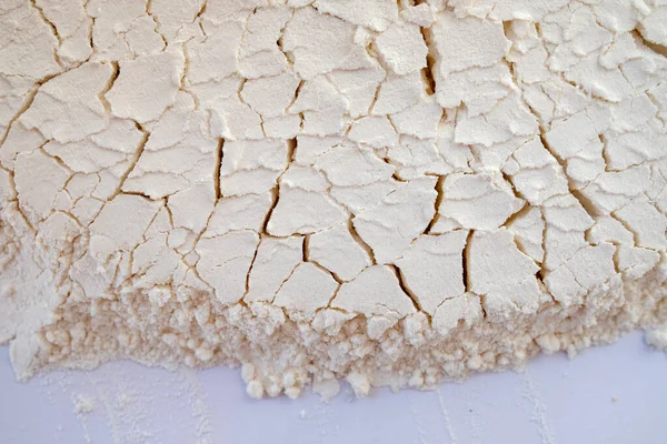 Çatlak beyaz un yüzey dokusu, soyut kabartma malzemesi arkaplanı, aşçılık tasarımı ve gıda ambalajı için ince toz detayı.