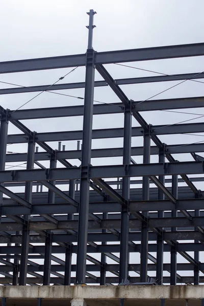 Şehir inşaatı için modern mimari, yapı mühendisliği ve endüstriyel tasarım elementlerinin sergilendiği kirişleri, çapraz destekleri ve merdiven platformları olan endüstriyel çelik iskelet.