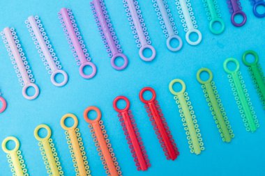 Renkli bir arka planda şeffaf plastik diş hizalayıcıları. Ortodontik silikon çalıştırıcı dikey pankart. Görünmez diş teli reklamı. Tıbbi web konsepti. Artıları, eksileri hizala.