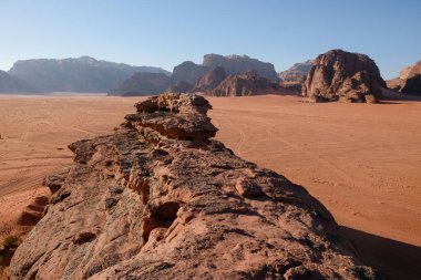 Dağları ve engin kumlu çölü olan kayalık bir arazi.